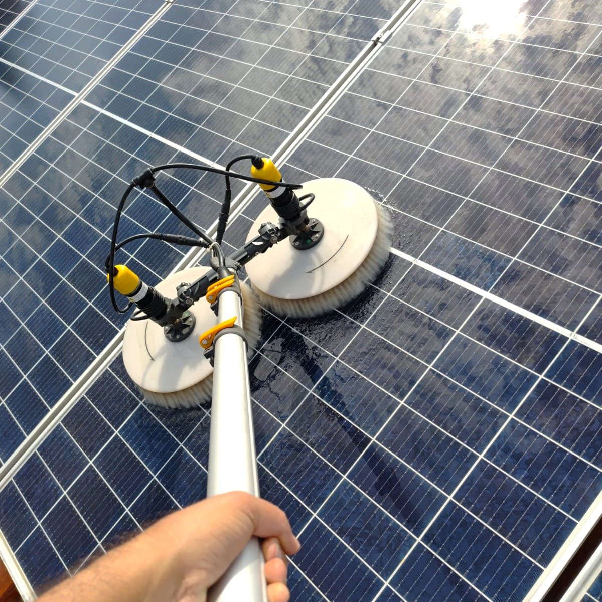 Técnico da Solareza Clean limpando placas solares com escova rotativa em Campo Grande MS