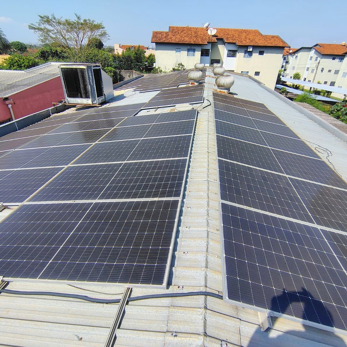 Sistema fotovoltaico comercial com dezenas de placas solares atendido pela Solareza Clean